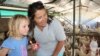 Farmer Ruth Mylroie witnesses a chicken laying an egg with a young visitor during a school tour of New Harmony Farm.
