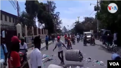 Protesters throw trash on street during a demonstration against President Jovenel Moise in Gonaïves, Haiti, June 14, 2019. 