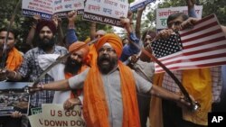 Miembros del Akali Dal, un partido político sij, muestran espadas y letreros de protesta en Nueva Delhi