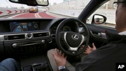 FILE - An employee of Toyota Motor Corp., drives automated driving test vehicle during a test drive of Toyota's self-driving technologies in Tokyo. Such cars are one field in which researchers are seeking to expand the limits of machine learning.