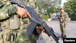 FILE- Colombian soldiers stand guard o a street in Caloto, Columbia, Feb. 6, 2014.