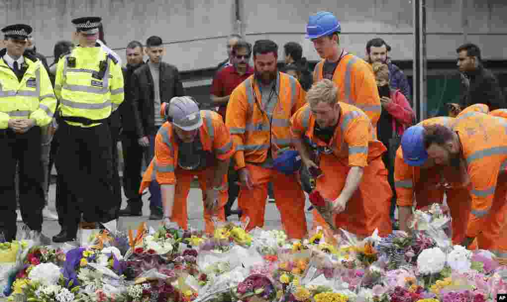 City workers lay flower tributes in the London Bridge area of London, June 5, 2017.