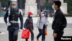 Para turis mengenakan masker di Chiang Kai Shek Memorial Hall di tengah perebakan virus corona di Taipei, Taiwan (foto: dok). 