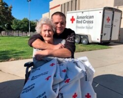 Jonathan Stahl, 41, of Valencia, Calif., and his 91-year-old grandmother Beverly Stahl of the Sylmar area of Los Angeles, pose at the evacuation center at the Sylmar Recreation Center after the Saddleridge wildfire, Oct. 11, 2019.