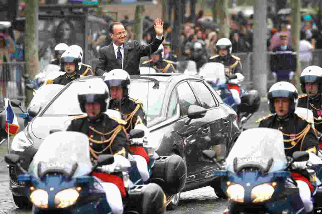 Francois Hollande drives down the Champs Elysees avenue in Paris after the handover ceremony.