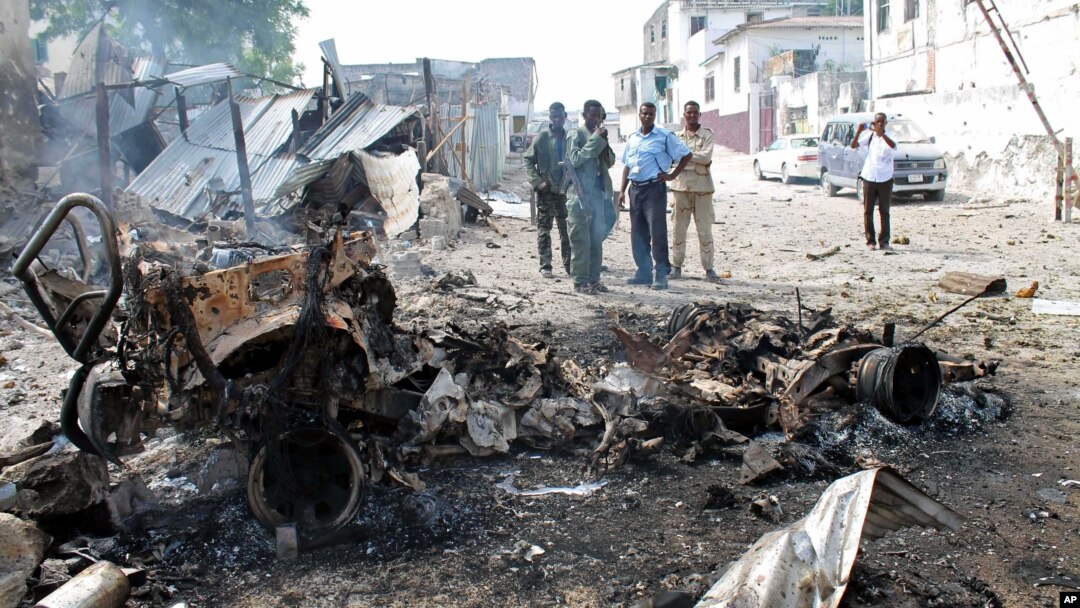Petugas keamanan Somalia melihat rongsokan bom mobil yang digunakan militan untuk menyerang komplek pengadilan di Mogadishu (14/4). 