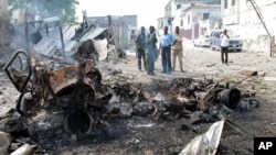 Petugas keamanan Somalia melihat rongsokan bom mobil yang digunakan militan untuk menyerang komplek pengadilan di Mogadishu (14/4). 