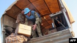 A handout photo released by the UNMISS shows peacekeepers of the United Nations distributing boxes of food to displaced people during a World Food Program (WFP) food distribution, Dec. 22, 2013.