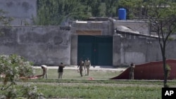 Pakistani army troops remove canvas screens from outside a house, where al-Qaida leader Osama bin Laden was caught and killed in Abbottabad, Pakistan, May 3, 2011