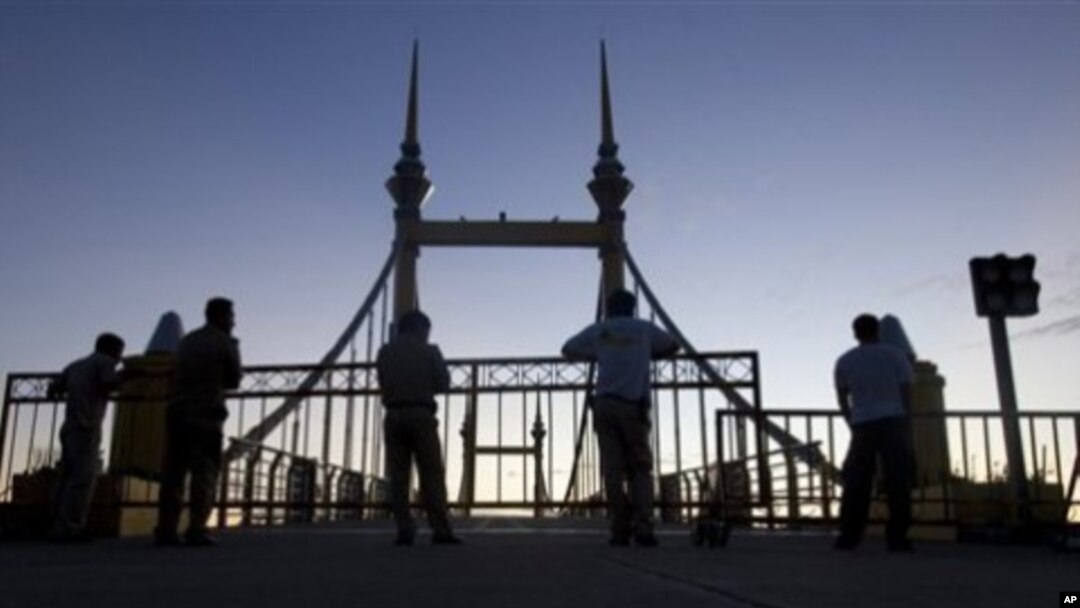 Cambodian police officers stand guard on a bridge where hundreds of people stampeded during a water festival in Phnom Penh, Cambodia, 28 Nov 2010