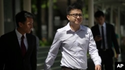 Yang Kaiheng, 27, co-founder of "The Real Singapore" website, right, arrives with his lawyer Choo Zheng Xi, left, at the State Court on Tuesday, June 28, 2016.