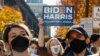 Seorang perempuan memegang poster Biden-Harris setelah media memproyeksikan Biden sebagai presiden terpilih di Philadelphia, Pennsylvania, 7 November 2020.