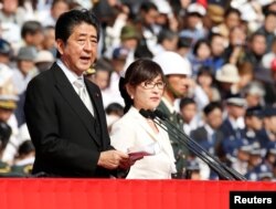 아베 신조(왼쪽) 일본 총리가 지난해 10월 이나다 도모미(가운데) 방위상이 배석한 가운데 자위대 행사에서 연설하고 있다.