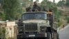 FILE - Ethiopian government soldiers ride in the back of a truck on a road leading to Abi Adi, in the Tigray region of northern Ethiopia, May 11, 2021.