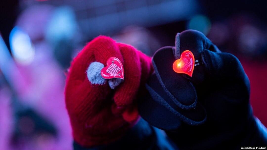 Sepasang kekasih menunjukkan cincin berbentuk hati pada hari Valentine di Manhattan, New York, Minggu, 14 Februari 2021. (Foto: Reuters)
