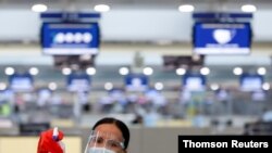 ARCHIVO - Una trabajadora limpia una superficie en un aeropuerto filipino. El uso de tecnologías libre de contacto dará más seguridad a los viajeros.