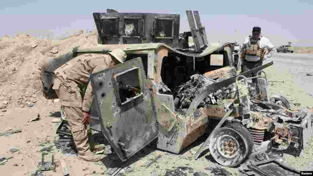 The wreckage of a Humvee belonging to Islamic State militants lies along a road after it was targeted by Iraqi security forces and Iraqi Shi'ite volunteers, in the town of Sulaiman Pek in Salahuddin province, Aug. 31, 2014. 