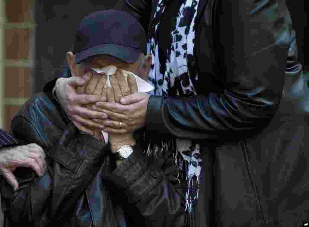 An elderly relative is comforted as the coffin of 17 year-old Vadim Papura is brought outside the apartment block he lived in, in Odessa, Ukraine, Tuesday, May 6, 2014. Papura died after jumping out of the burning trade union building in an attempt to escape Friday&#39;s fire that killed most of the 40 people that died after riots erupted last Friday. (AP Photo/Vadim Ghirda)
