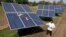 Farmer Pravinbhai Parmar cleans a solar panel installed at a farm in Dhundi village of Kheda district in western Indian Gujarat state, India, Jan. 13, 2023. 