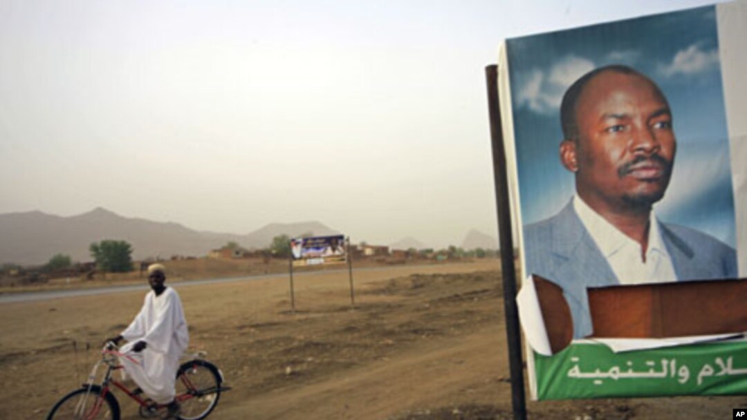 A man cycles past a gubernatorial election campaign billboard of NCP candidate for the governor's post Ahmed Haroun at Kadogli town, South Kordofan State, May 1, 2011