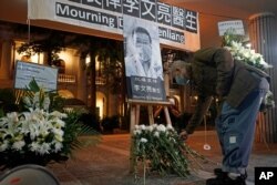A man wearing a face mask attends a vigil for Chinese doctor Li Wenliang, in Hong Kong, Feb. 7, 2020.