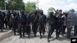 ARCHIVO - Policías persiguen a manifestantes en Managua, Nicaragua, en abril de 2018. 