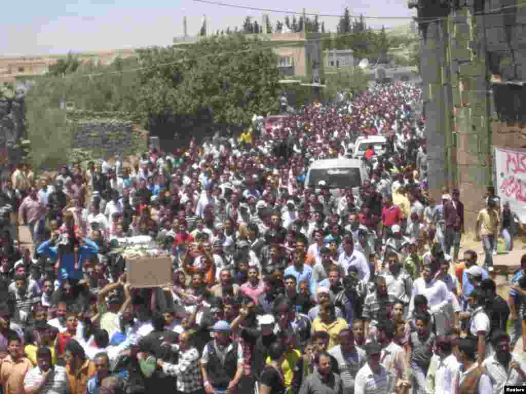 Syrian residents carry the body of Abed Al-Razaq Al-Zubi, whom protesters say was killed by forces loyal to Syria&#39;s President Bashar al-Assad, during his funeral in Dara, June 8, 2012.