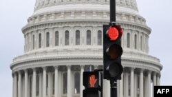 A stoplight is seen in front of the dome of the US Capitol as a government shut down looms in Washington, DC, on September 28, 2023.