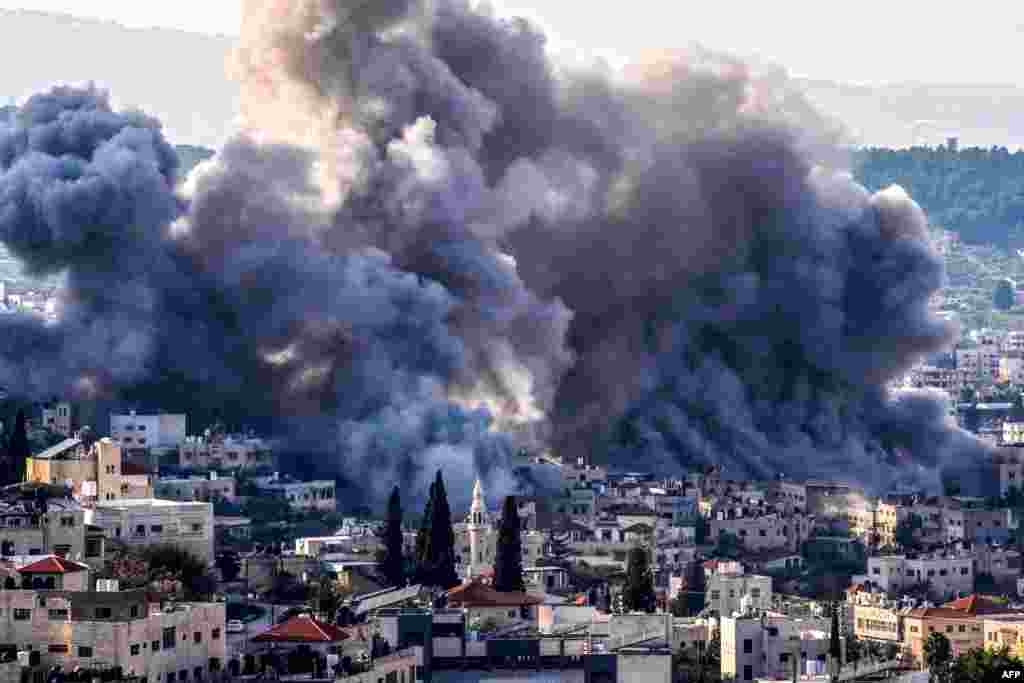 Smoke billows from the site of several explosions during an Israeli raid on the Jenin camp for Palestinian refugees.