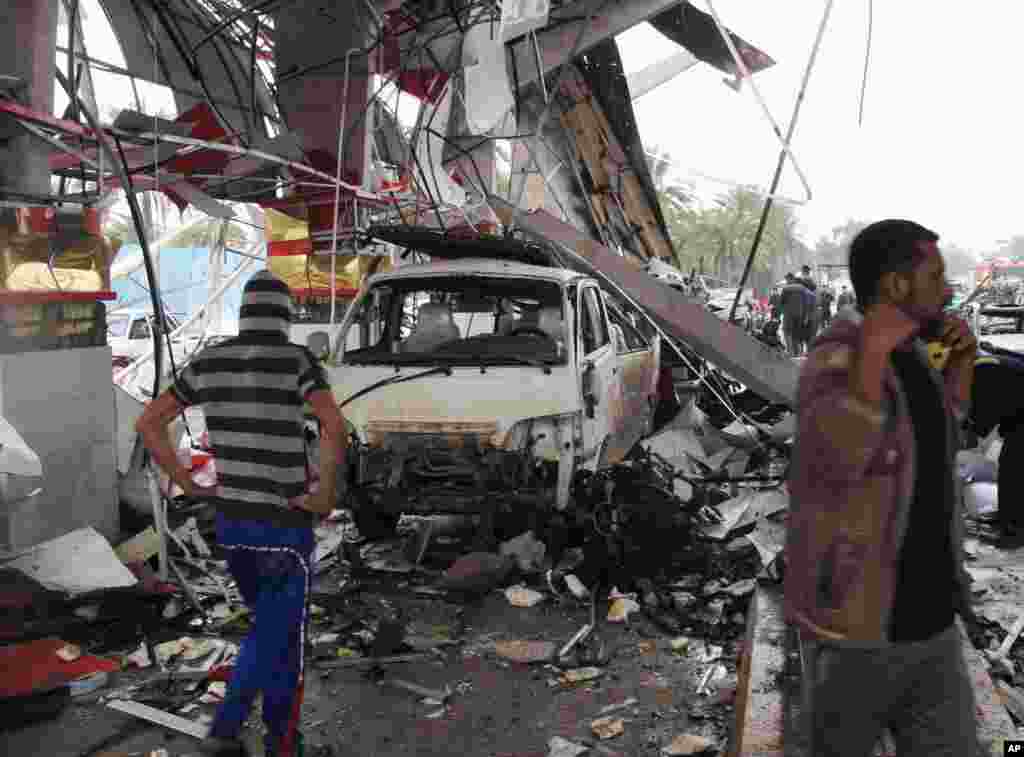 Civilians inspect the site of a massive bomb attack in Hillah, Iraq, March 9, 2014.&nbsp;