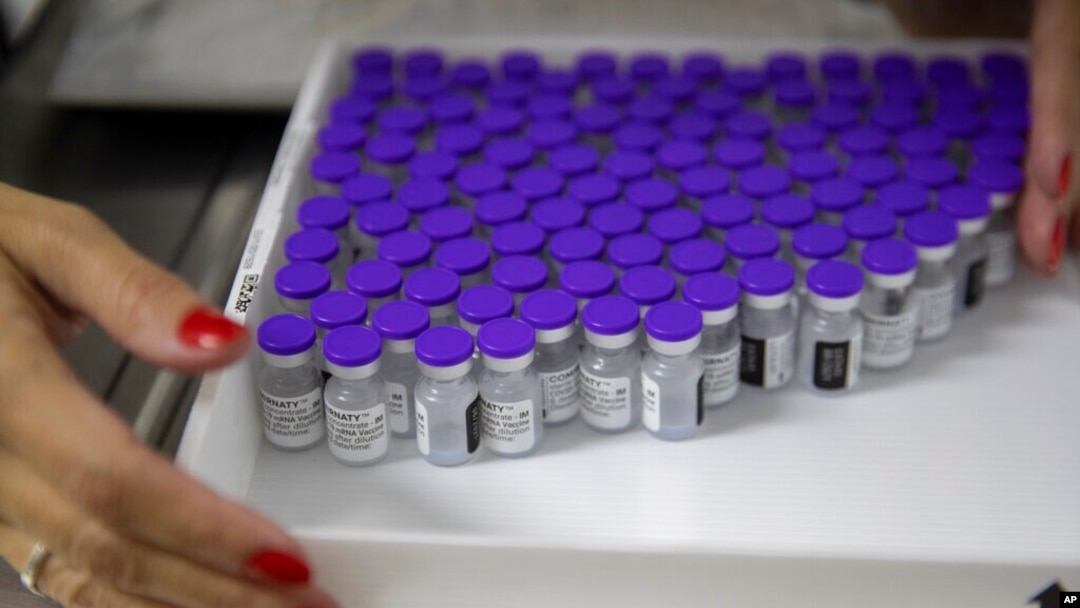 FILE - A health worker holds a tray with vials of the Pfizer vaccine for COVID-19 during a priority vaccination program at a community medical center in Sao Paulo, Brazil, May 6, 2021. 