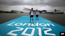 Rower Oksana Masters and her rowing partner, Rob Jones from the United States, carry their oars after a training session ahead of the 2012 Paralympics Olympics in Eton Dorney, near Windsor, England, August 29, 2012.