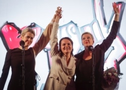 FILE - Sviatlana Tsikhanouskaya, presidential candidate (C), Veronika Tsepkalo, wife of opposition figure Valery Tsepkalo (L), and Maria Kolesnikova, campaign representative of another opposition candidate, gesture in Minsk, Belarus, July 30, 2020.