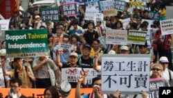 FILE - Protesters rally Nov. 7, 2015, against the meeting of Taiwan President Ma Ying-jeou and China counterpart Xi Jinping in Singapore outside of the Songshan Airport in Taipei, Taiwan.