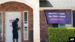 A security guard opens the door to the Whole Women's Health Clinic in Fort Worth, Texas, Sept. 1, 2021.