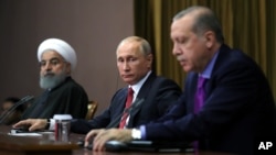 Turkey's President Recep Tayyip Erdogan, right, Russia's President Vladimir Putin, center, and Iran's President Hassan Rouhani are seen at a news conference in Russia's Black Sea resort of Sochi, Russia, Nov. 22, 2017. The three are due to meet Wednesday 
