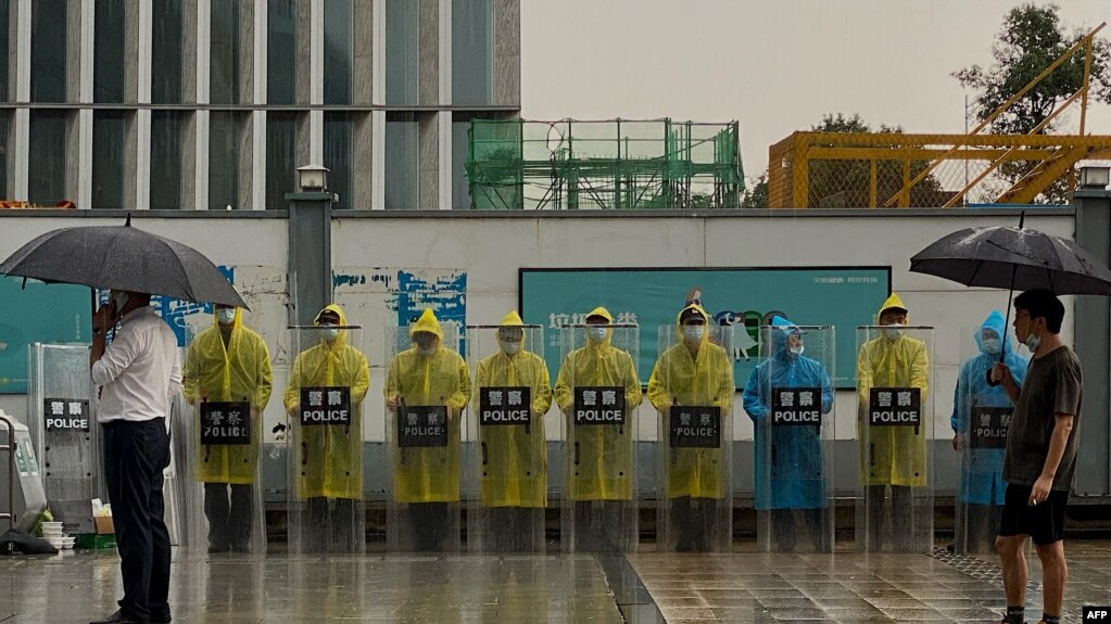 位于深圳的恒大集团总部外警察穿着雨衣在站岗。（2021年9月14日）