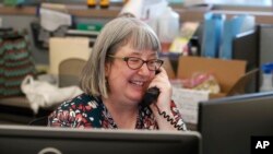 Librarian Holly Ryckman smiles as she chats with 81-year-old Dell Kaplan from the Davis Library in Plano, Texas Friday, May 15, 2020. (AP Photo/LM Otero)