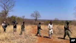 Some of Mander's rangers on patrol with an American television crew in a wildlife park in Zimbabwe