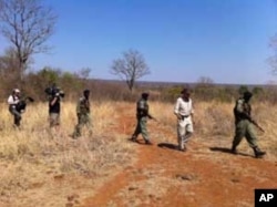 Some of Mander’s rangers on patrol with an American television crew in a wildlife park in Zimbabwe