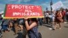 FILE - Supporters of the Deferred Action for Childhood Arrivals, or DACA chant slogans and carry signs while joining rally in downtown Los Angeles, Sept. 4, 2017.