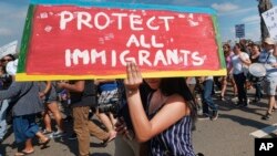 FILE - Supporters of the Deferred Action for Childhood Arrivals, or DACA chant slogans and carry signs while joining a Labor Day rally in downtown Los Angeles.