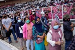 People line up to get vaccinated with the Sinovac COVID-19 vaccine during a mass vaccination at Gelora Bung Karno Main Stadium in Jakarta, Indonesia, June 26, 2021.