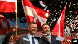 FILE - In this May 20, 2016 file photo Norbert Hofer candidate for presidential elections of Austria's Freedom Party, FPOE, and Heinz-Christian Strache, from left, head of Austria's Freedom Party, FPOE, look out at supporters during the final election cam