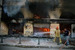 Firefighters extinguish a fire at a branch of the Credit Libanais Bank that was burnt by anti-government protesters, in the northern city of Tripoli, Lebanon, April 28, 2020.