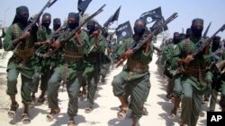 FILE - Al-Shabab fighters march with their weapons during military exercises on the outskirts of Mogadishu, Somalia, Feb. 17, 2011.