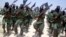 FILE - Al-Shabab fighters march with their weapons during military exercises on the outskirts of Mogadishu, Somalia, Feb. 17, 2011.