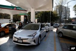 Vehicles stand in line to fill up their fuel tanks at a gas station in Mexico, City, Jan. 8, 2019.