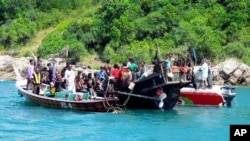 Sebuah kapal bermuatan 73 orang pengungsi muslim Rohingya dikawal oleh pihak berwenang di lepas pantai Phuket, selatan Thailand (1/1).