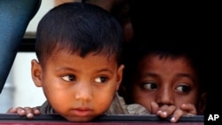 Rohingya minority children look out through a window of a bus after they were rescued by Thai authorities in Songkhla province, southern Thailand, Jan. 11, 2013. Nearly 700 boat people from Myanmar's beleaguered Rohingya minority were rescued from alleged human traffickers in two separate raids near Thailand’s southern border.